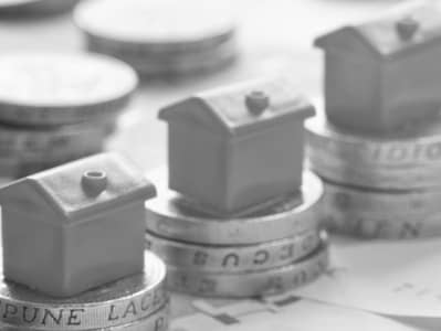 Image of model house on piles of pound coins