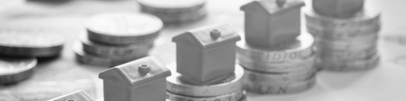 Image of model house on piles of pound coins