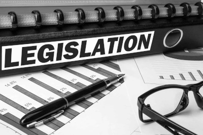 Image of ring file with  Legislation printed on spine with glasses and pen