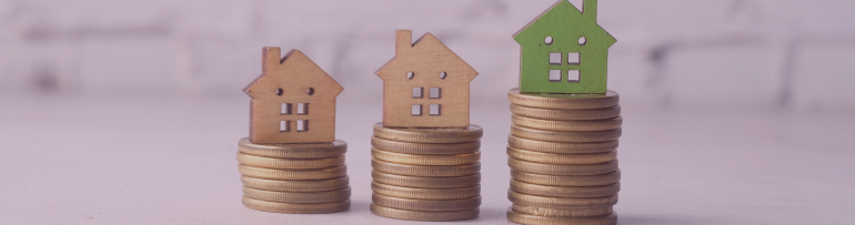 Image of wooden model houses with on pound coins