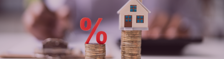 Image of a little model house and percentage on separate piles of coins