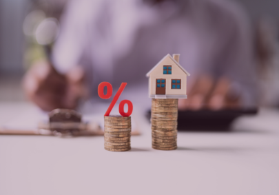 Image of a little model house and percentage on separate piles of coins
